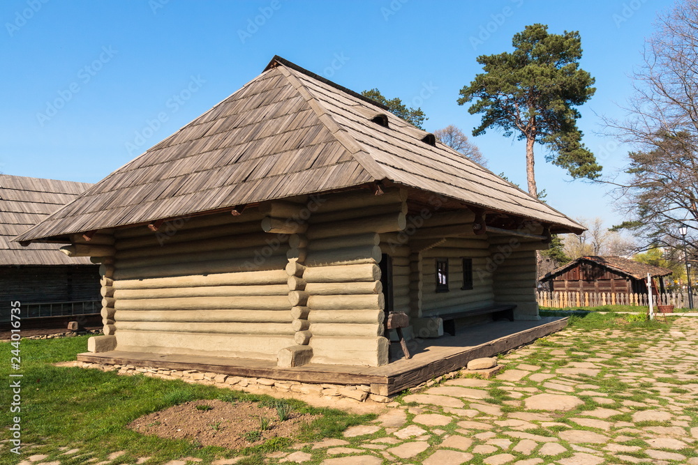 Old traditional rustic wooden house coated with clay, with wide porch, from Suceava county, Romania. Old traditional rustic wooden house coated with clay, with wide porch, from Suceava county, Romania.