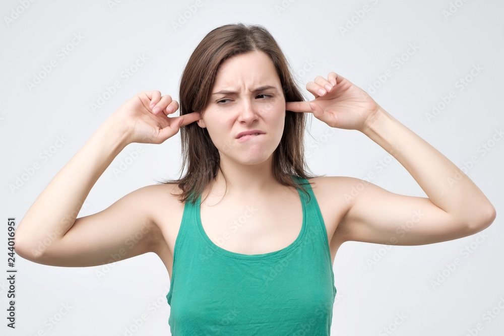 woman plugging ears pretending not to hear what she is told woman plugging ears pretending not to hear what she is told