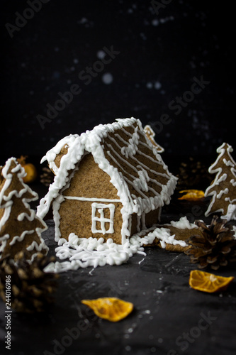 Gingerbread house on black night background, ginger cookies christmas dark photo