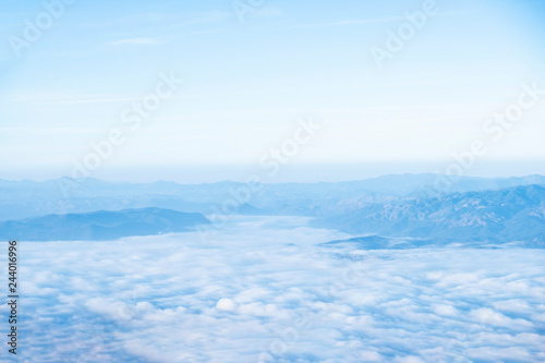 Blue sky background with white clouds at the morning.Mist in the morning on the mountain.