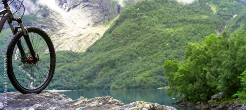 Mountain bike wheel and mountain lake landscape, Norway