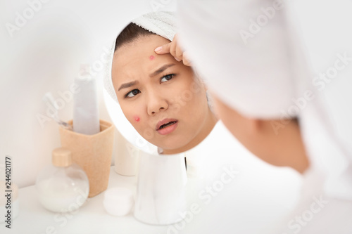 Young asian woman examining...