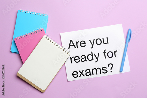 Notebooks and paper with text ARE YOU READY FOR EXAMS? on color background
