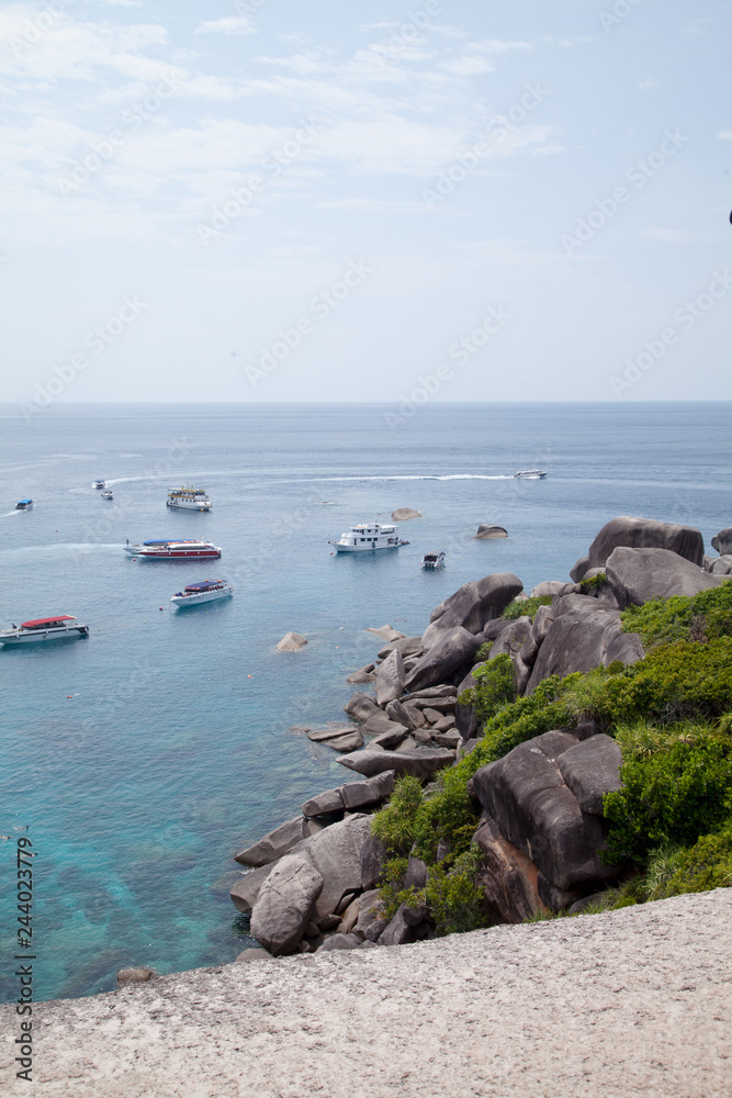 yachts on the background of clear blue water, rainforest and rocks. tropics. Similan Islands