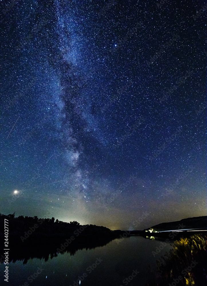 Milky way and stars over the forest and river.