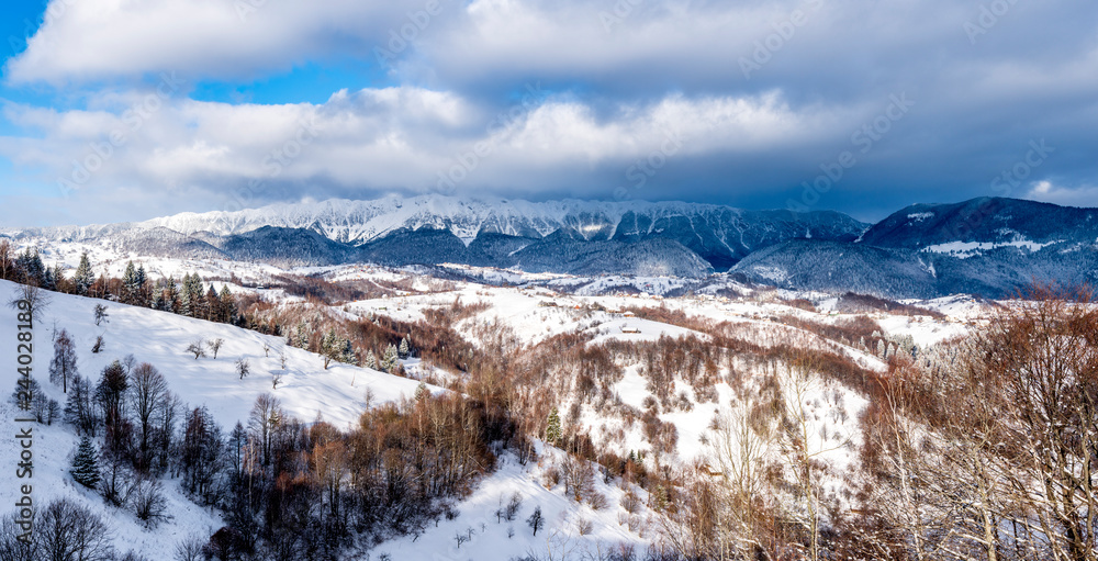 Brasov - Romania, Rucar - Bran snowy picturesque hills on a sunny cold December. Wide panorama of the Carpathian mountains.