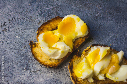 Crispy baguette toasts soft boiled egg and light blue rustic background. photo