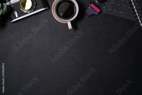 Office leather dark desk with vintage camera, films, coffee and copy space