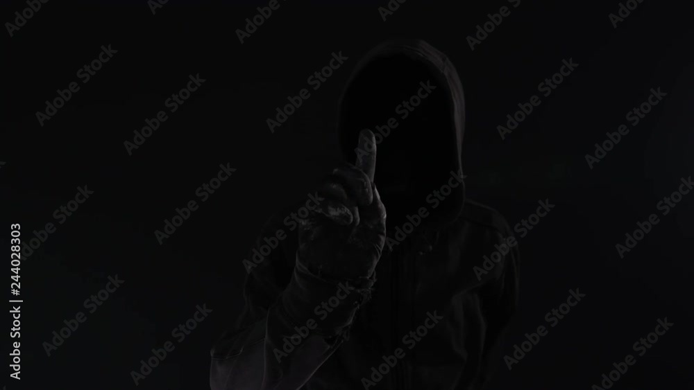Cybercrime concept with faceless hooded male person, low key footage with digital glitch effect