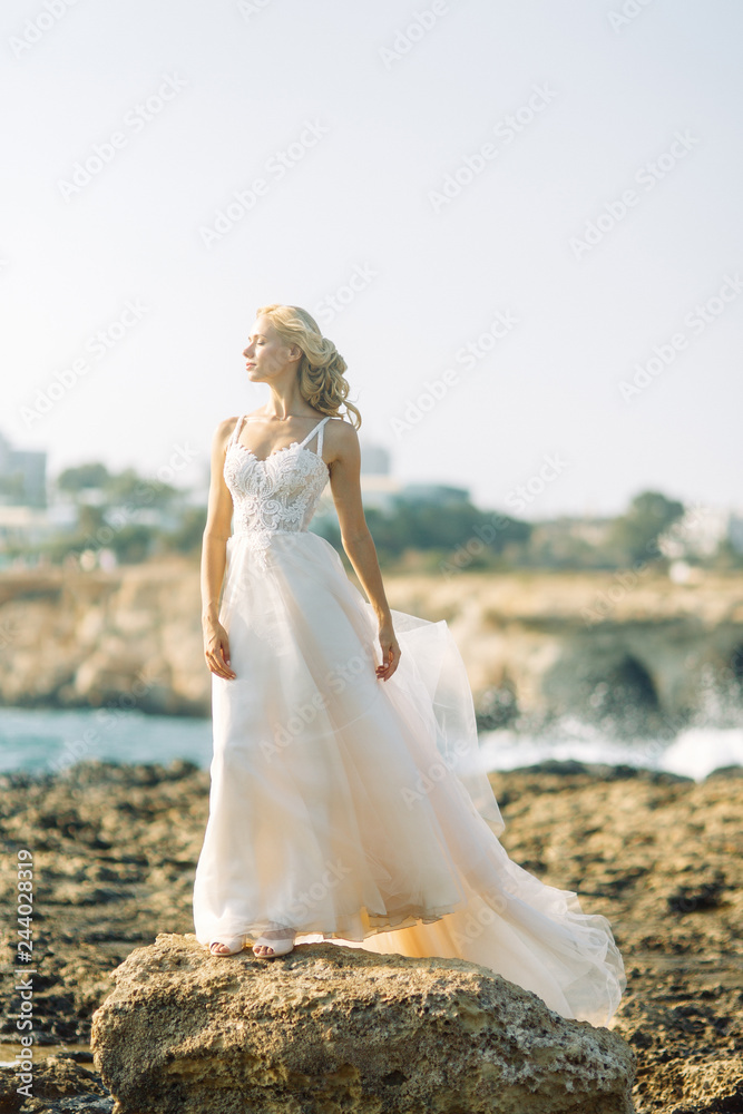 Bride on the beach in Cyprus. Sunset photo shoot of a beautiful girl.