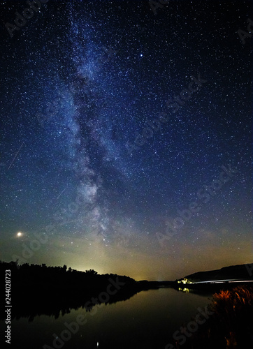 Milky way and stars over the forest and river.