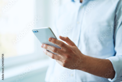 Close-up of young man holding smartphone