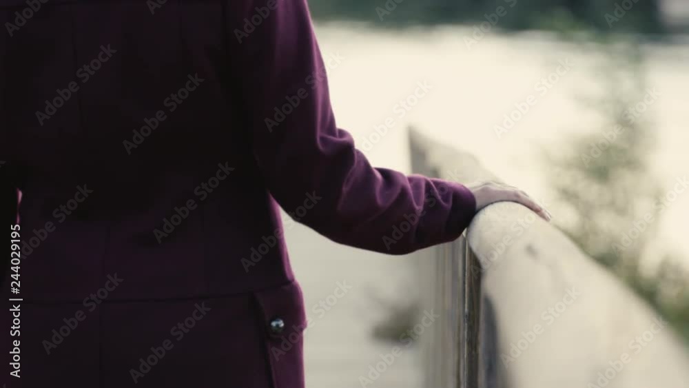 Mujer deslizando mano por barandilla madera embarcadero rio plano corto