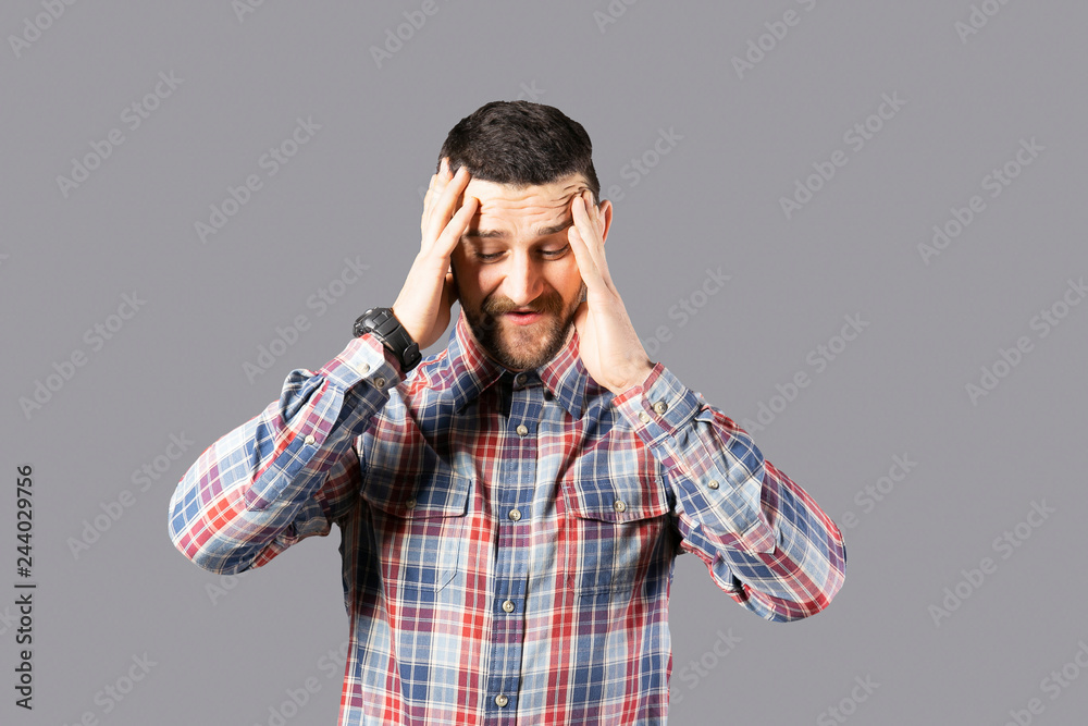 Body language concept. Young handsome man with facial hair posing over gray wall showing emotions. Portrait of masculine bearded male, wearing slim fit checkered shirt. Isolated background, copy space Body language concept. Young handsome man with facial hair posing over gray wall showing emotions. Portrait of masculine bearded male, wearing slim fit checkered shirt. Isolated background, copy space