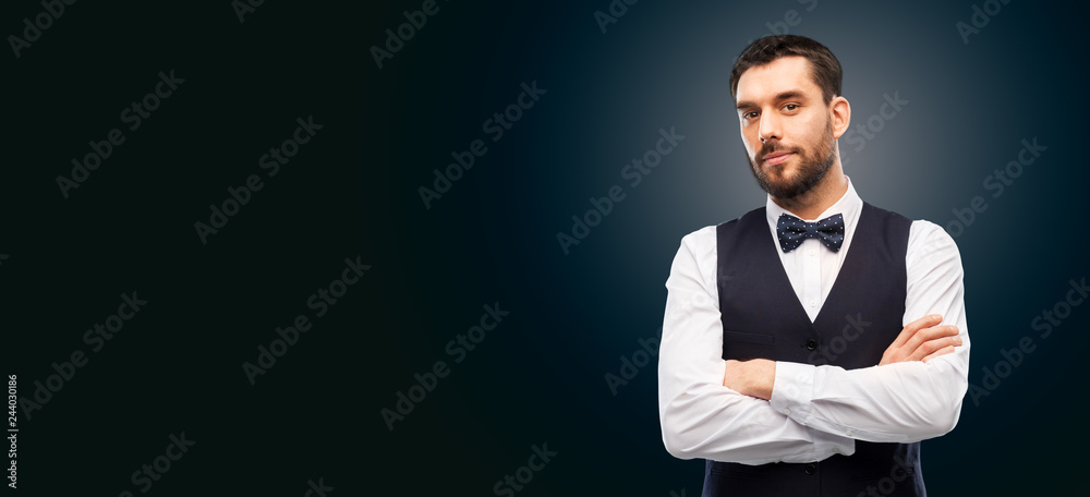 people concept - serious man in white shirt, waistcoat and bowtie over black background people concept - serious man in white shirt, waistcoat and bowtie over black background