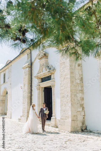 Wedding on the city streets of Cyprus. Beautiful couple walking and laughing, the architecture of the city. © pavelvozmischev