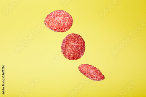 Abstract Flying Salami on Yellow Background Food Concept