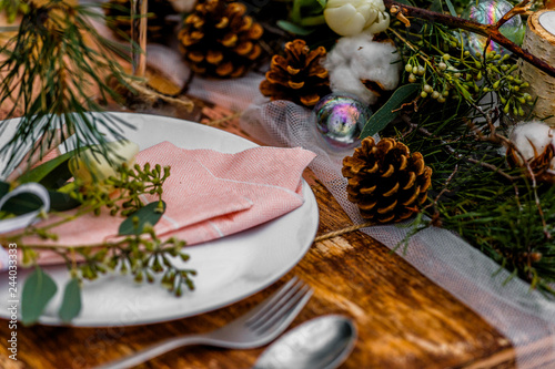 Wedding old wooden table with decoration full of flowers and placement prepared for food during the wedding ceremony in winter on snow in the middle of forest covered with fresh snow