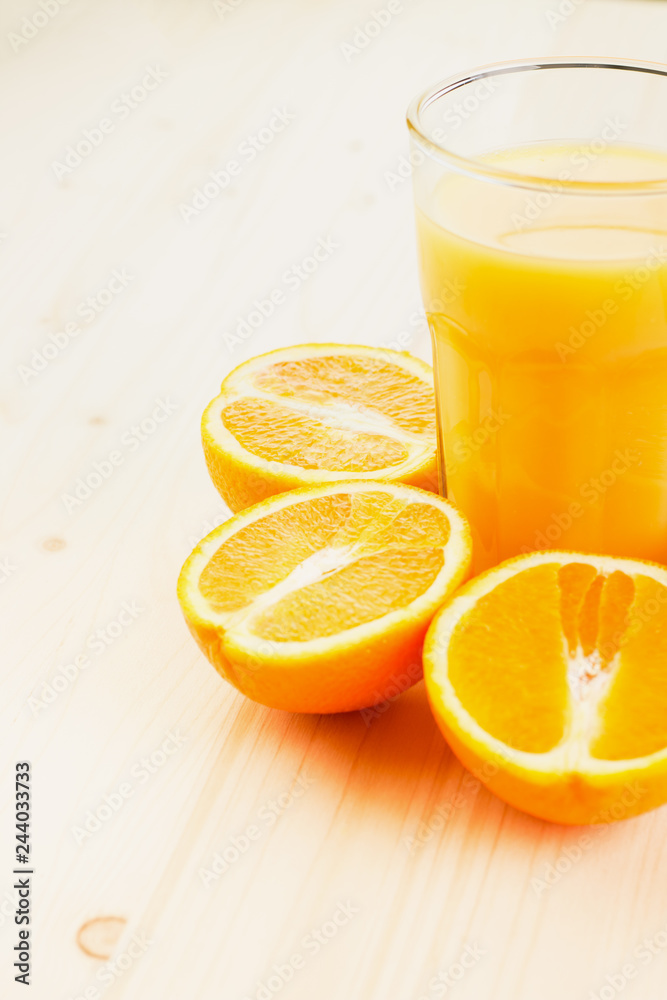 Glass of freshly pressed orange juice with sliced orange halfs Glass of freshly pressed orange juice with sliced orange halfs
