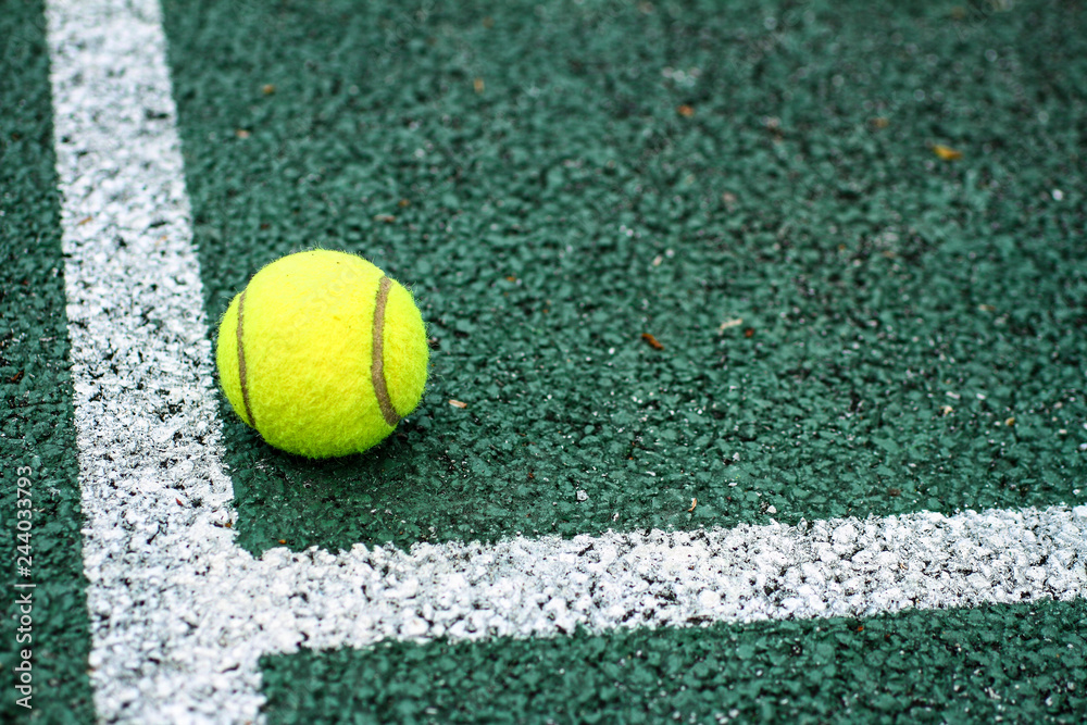 Close up of a tennis ball on a hard court