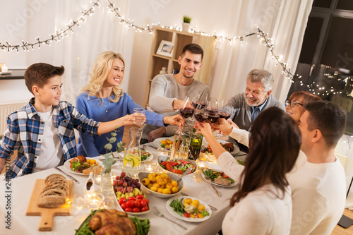 celebration  holidays and people concept - happy family having dinner party  drinking red wine and toasting at home