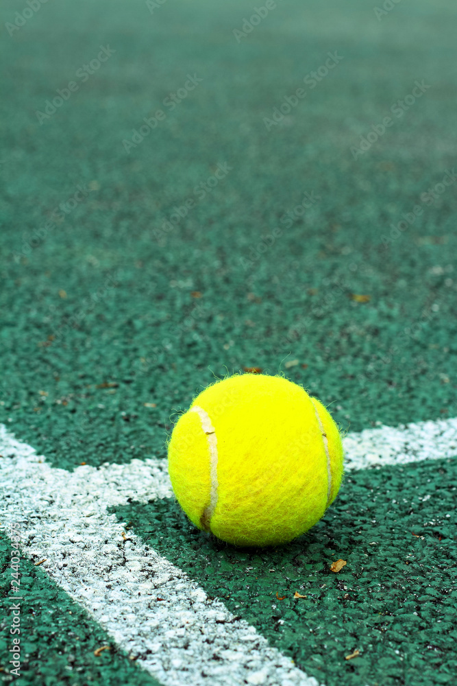 Close up of a tennis ball on a hard court with space for copy