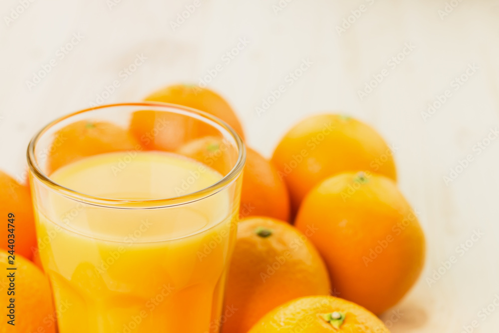 Glass of freshly pressed orange juice with oranges Glass of freshly pressed orange juice with oranges
