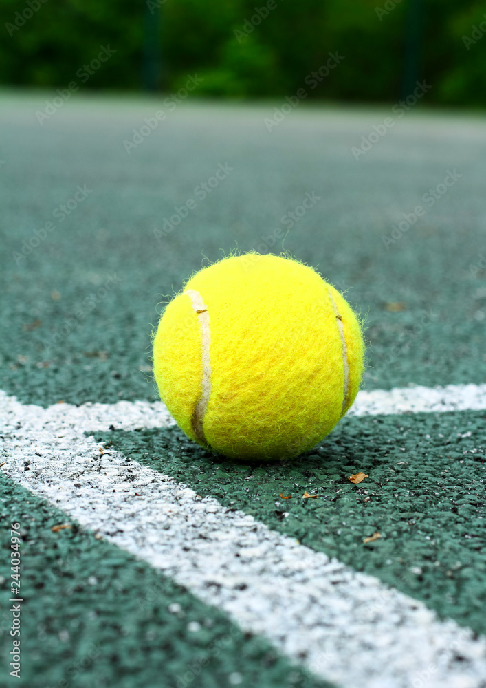Close up of a tennis ball on a hard court