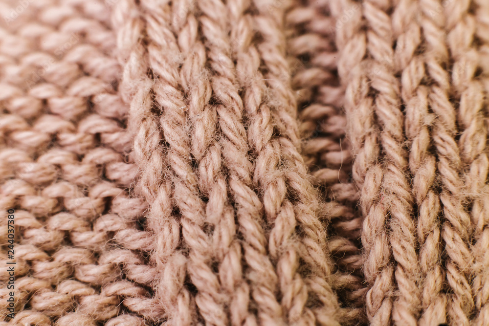 Texture of knitted woolen brown fabric for wallpaper and an abstract background. Soft focus