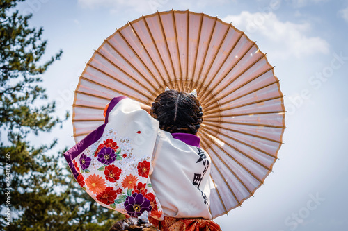 Japanese girl carrying traditional umbrella during a spring festival.