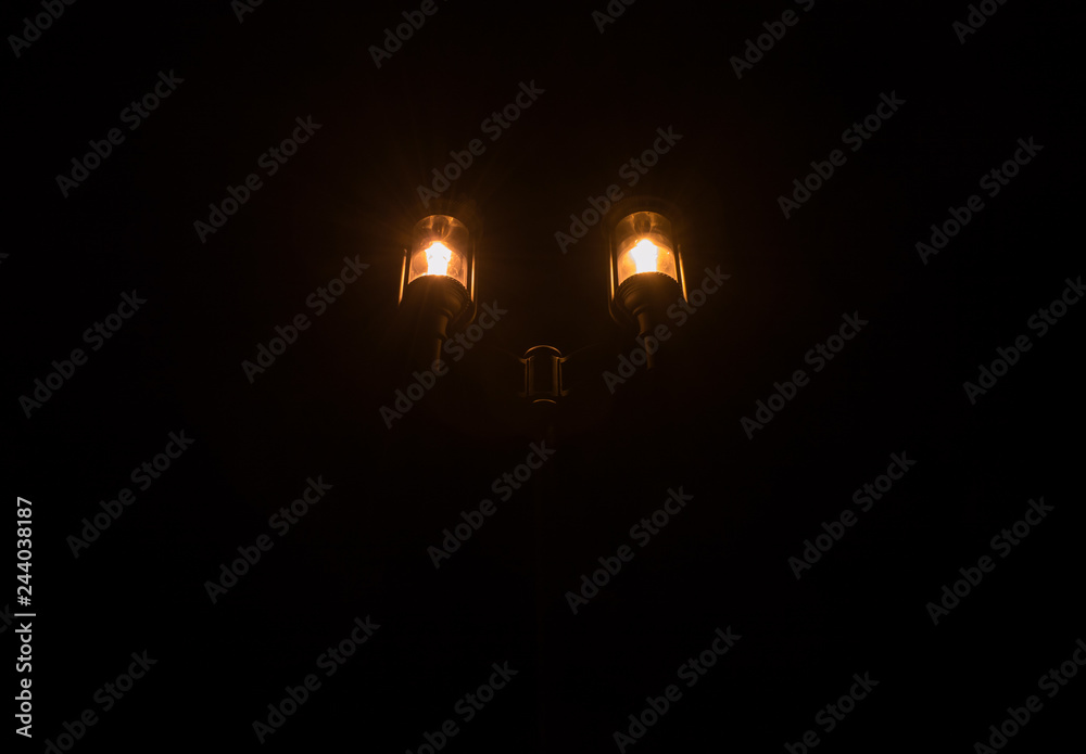 Night glowing street lamp on a black background