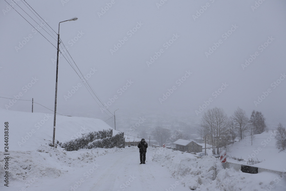 Stepantsminda Village in a snowstorm in winter in Kazbegi District , Mtskheta-Mtianeti Region, Georgia.