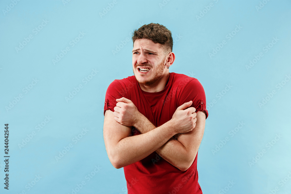 Young boy with a surprised unhappy failure expression bet slip on blue studio background. Human facial emotions and betting concept. Trendy colors Young boy with a surprised unhappy failure expression bet slip on blue studio background. Human facial emotions and betting concept. Trendy colors