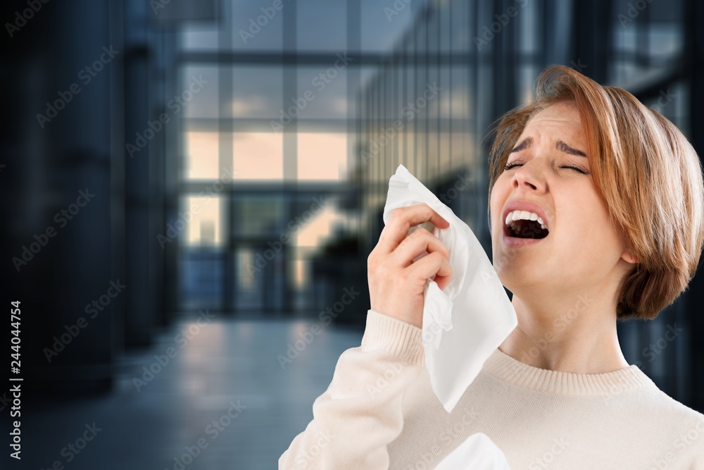 Fototapeta premium Cold woman holding handkerchieif blowing nose