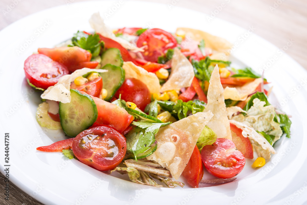 Fresh salad with tomato, cucumber, corn and chips Fresh salad with tomato, cucumber, corn and chips