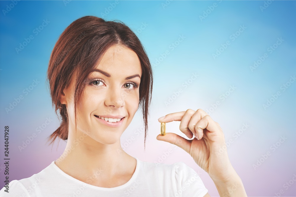 Woman taking a tablet. Close up hand with a pill and the mouth