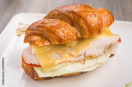 Closeup of tasty croissant with meat and cheese
