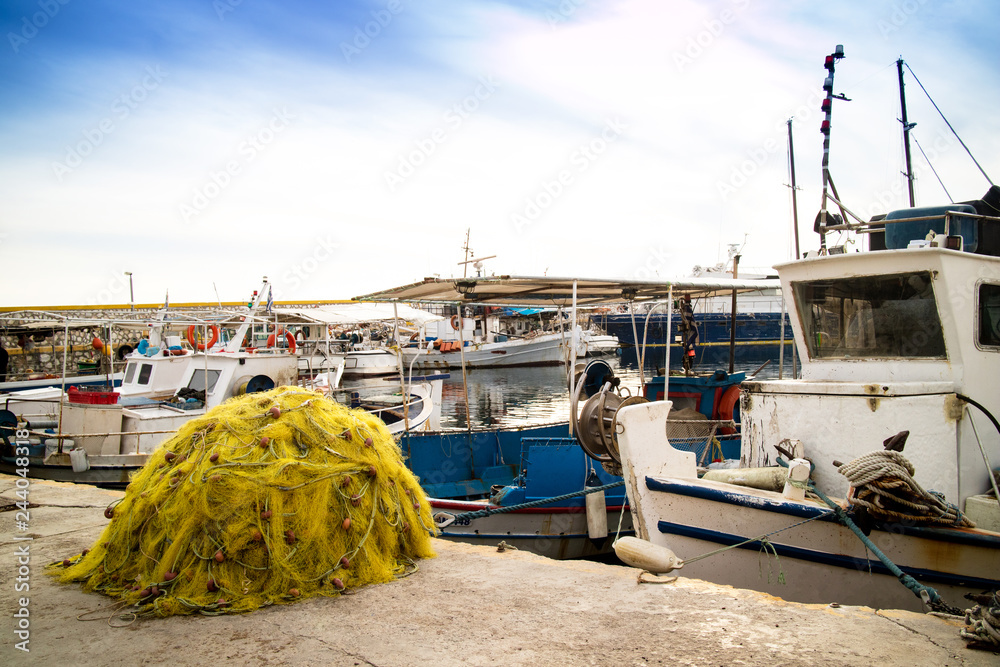 The mountain from the fishing net lies on the pier near the old fishing  boats Stock Photo