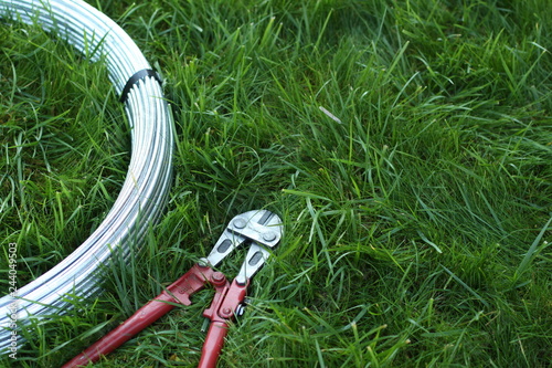 bolt cutter near the coil wire on the grass photo
