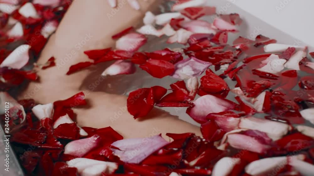beautiful sexy young blond woman in bath with rose petals