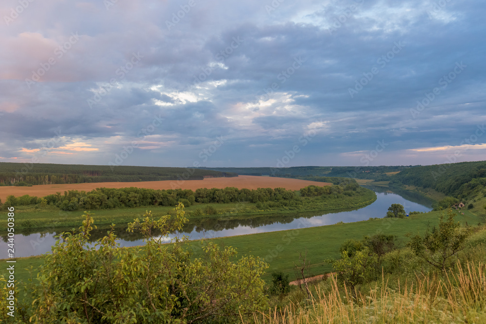 Fototapeta premium sunset over fields and river