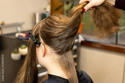 Stylist preparing brunette woman's hair for a color and highlight process
