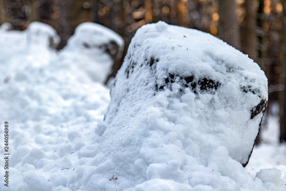 a snowy boundary stone on the mountain road. Aged border stone on the winter way in the mountain. a snowy boundary stone on the mountain road. Aged border stone on the winter way in the mountain.