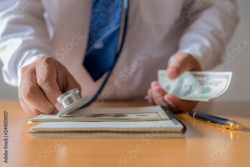 Financial analysis, audit or accounting - Stethoscope over a calculator and dollar bills. Medical costs, financial concept photo