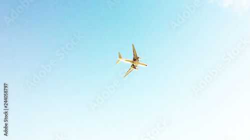 airplane in the blue clear sky  view from below of flying aeroplane. low angle shot background with copy space.