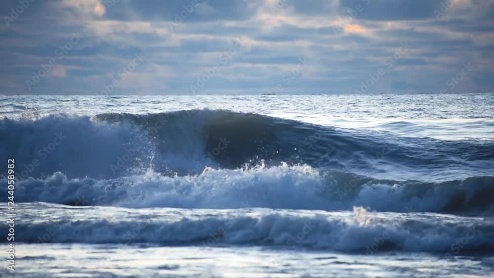 Silhouette of a surfer on the board among the waves in a stormy sea Silhouette of a surfer on the board among the waves in a stormy sea