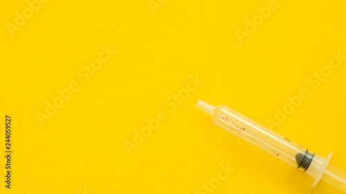 Syringe on yellow background