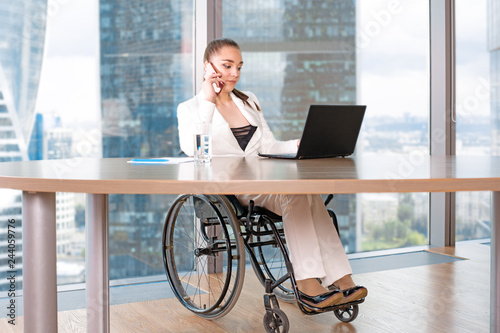 Obraz na plátně Invalid or disabled young business woman person sitting wheelchair working in of