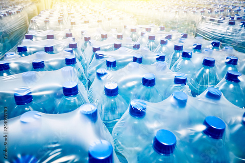 Many packaged blue mineral water bottles photo