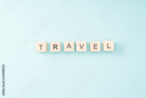 top view of wooden cubes with travel lettering on blue background
